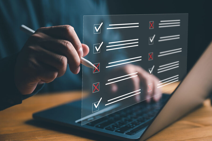 Businessman working on laptop computer productivity checklist and filling survey form