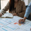 Business people looking over charts and analytical data at a large desk