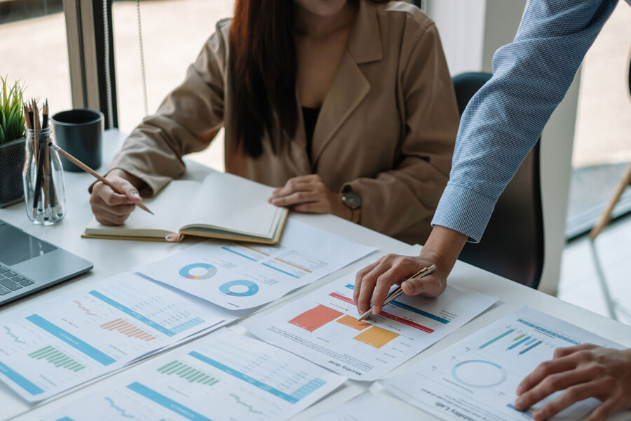 Business people looking over charts and analytical data at a large desk